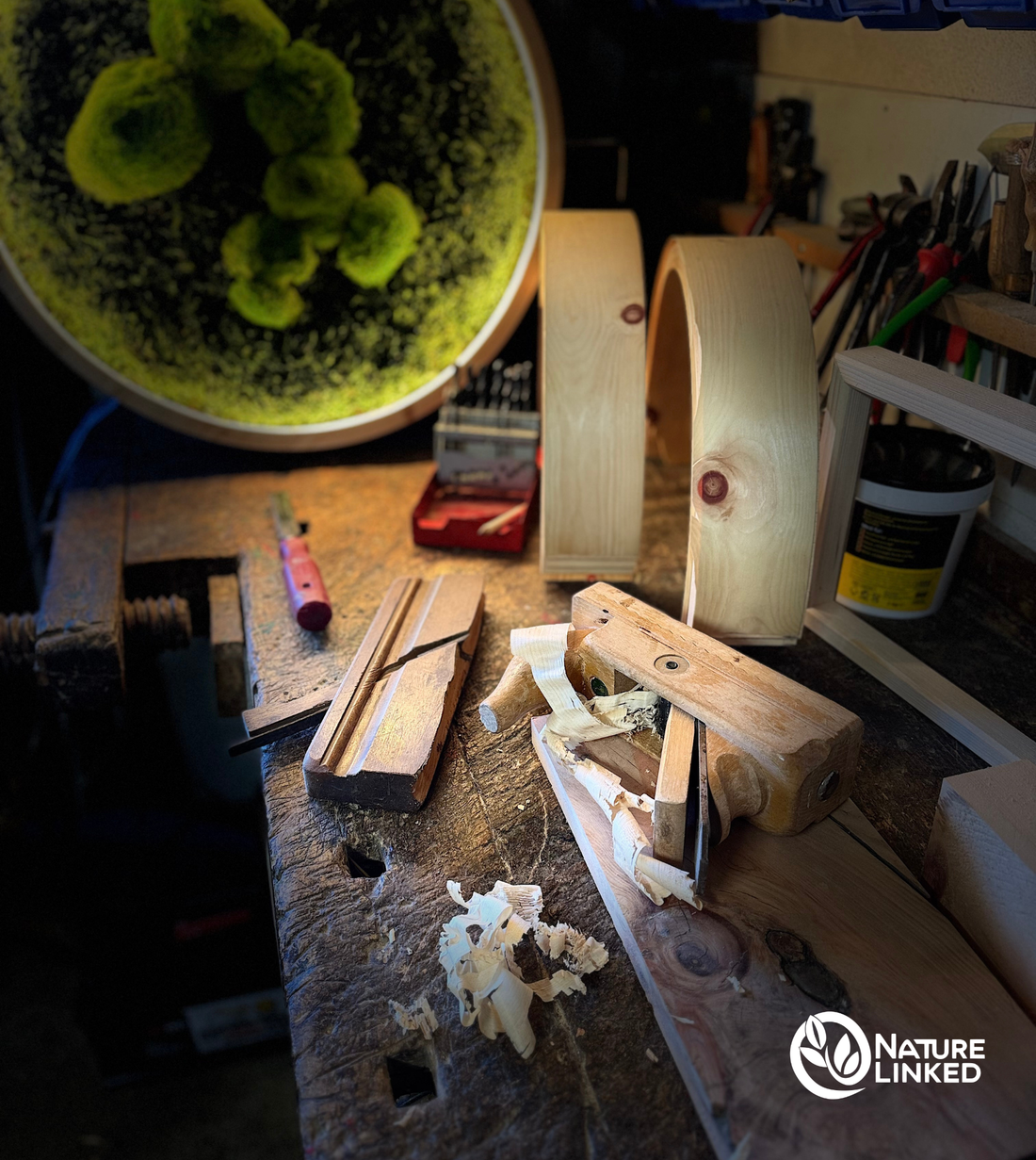 Werkbank mit Zirbenholz, Handwerkzeugen und Holzspänen in der Werkstatt